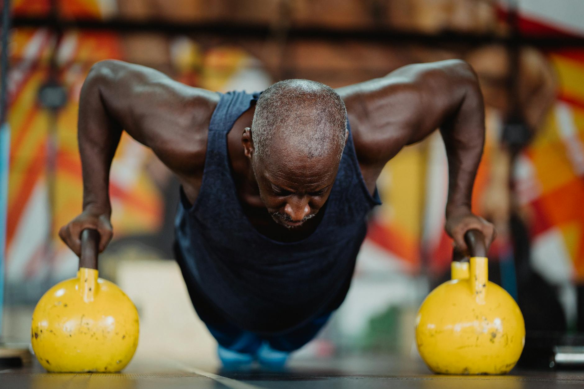 Man holding a kettlebell with focused expression.
